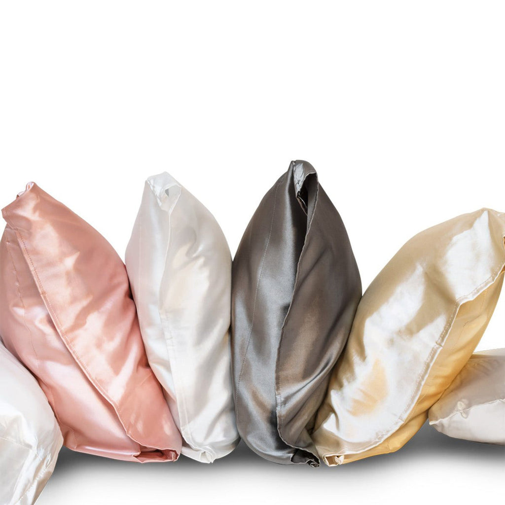fanned out pillows with satin pillowcases in white, blush, gunmetal and champagne