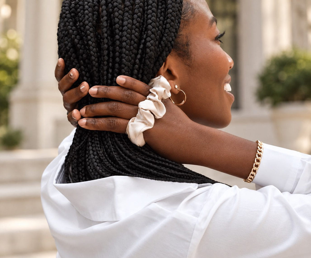 Champagne NIGHT Classic silk scrunchie worn on a wrist beside braided hair