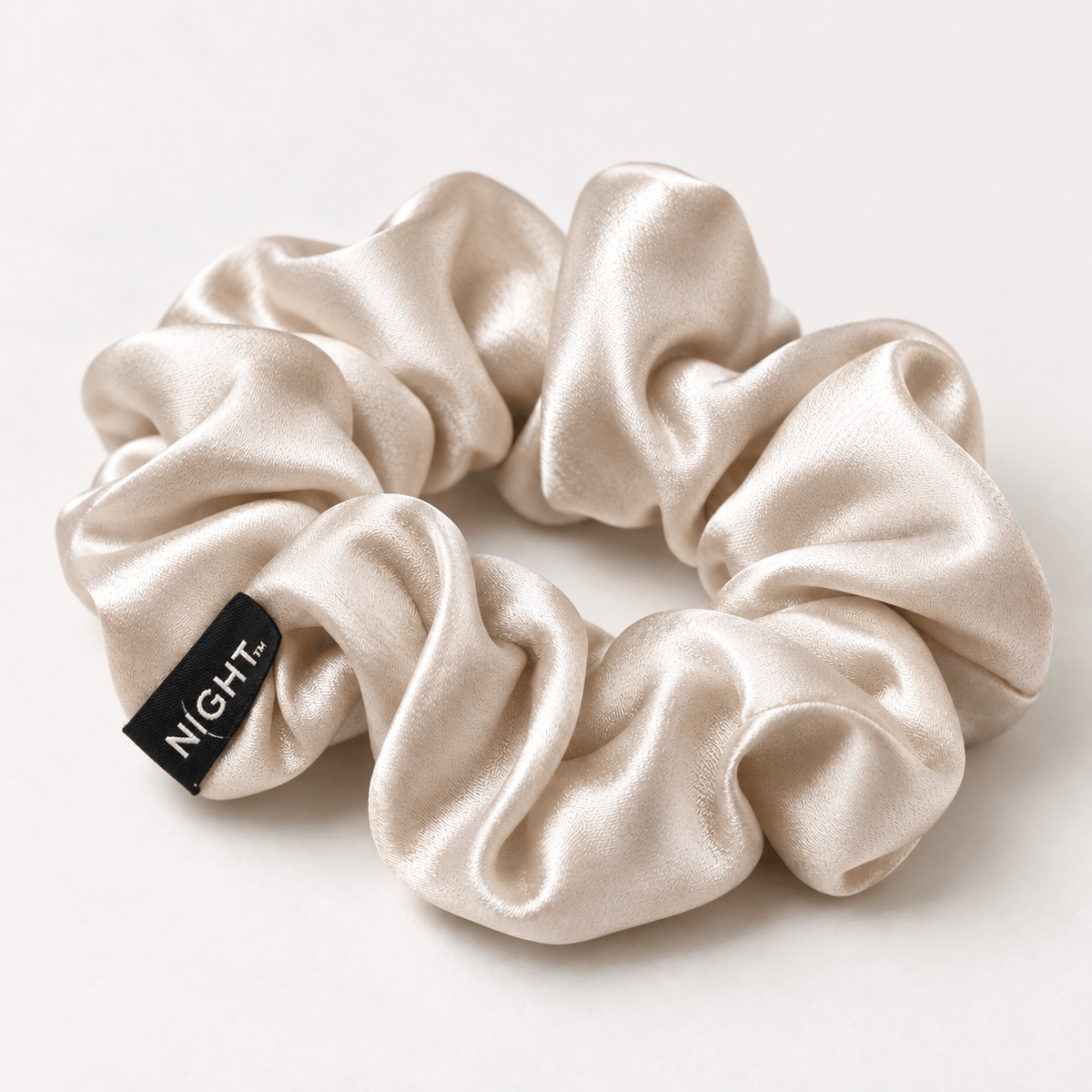 Champagne NIGHT Classic silk scrunchie close-up with black NIGHT tag