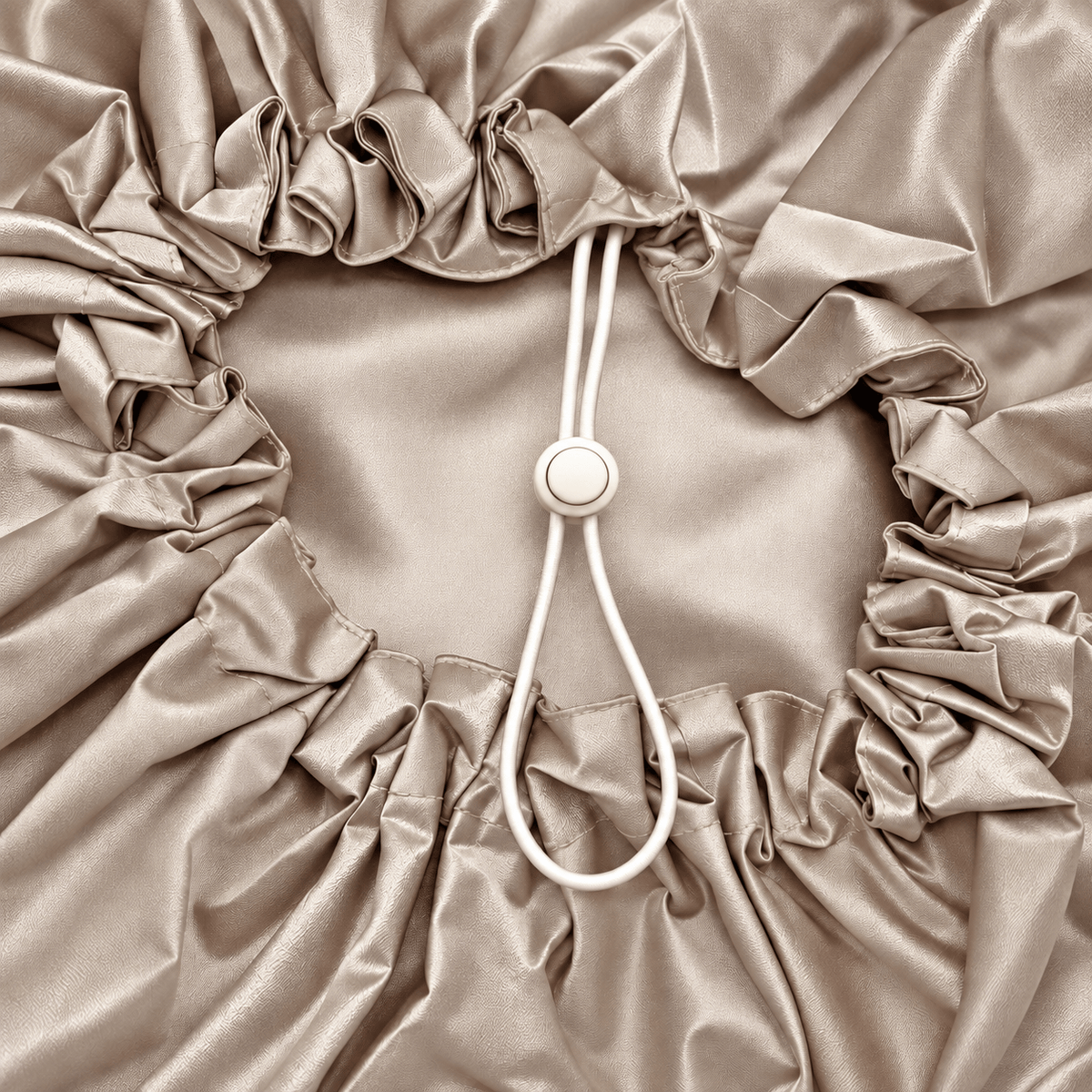 Close-up of the shower cap's single adjustable button toggle and elastic cord