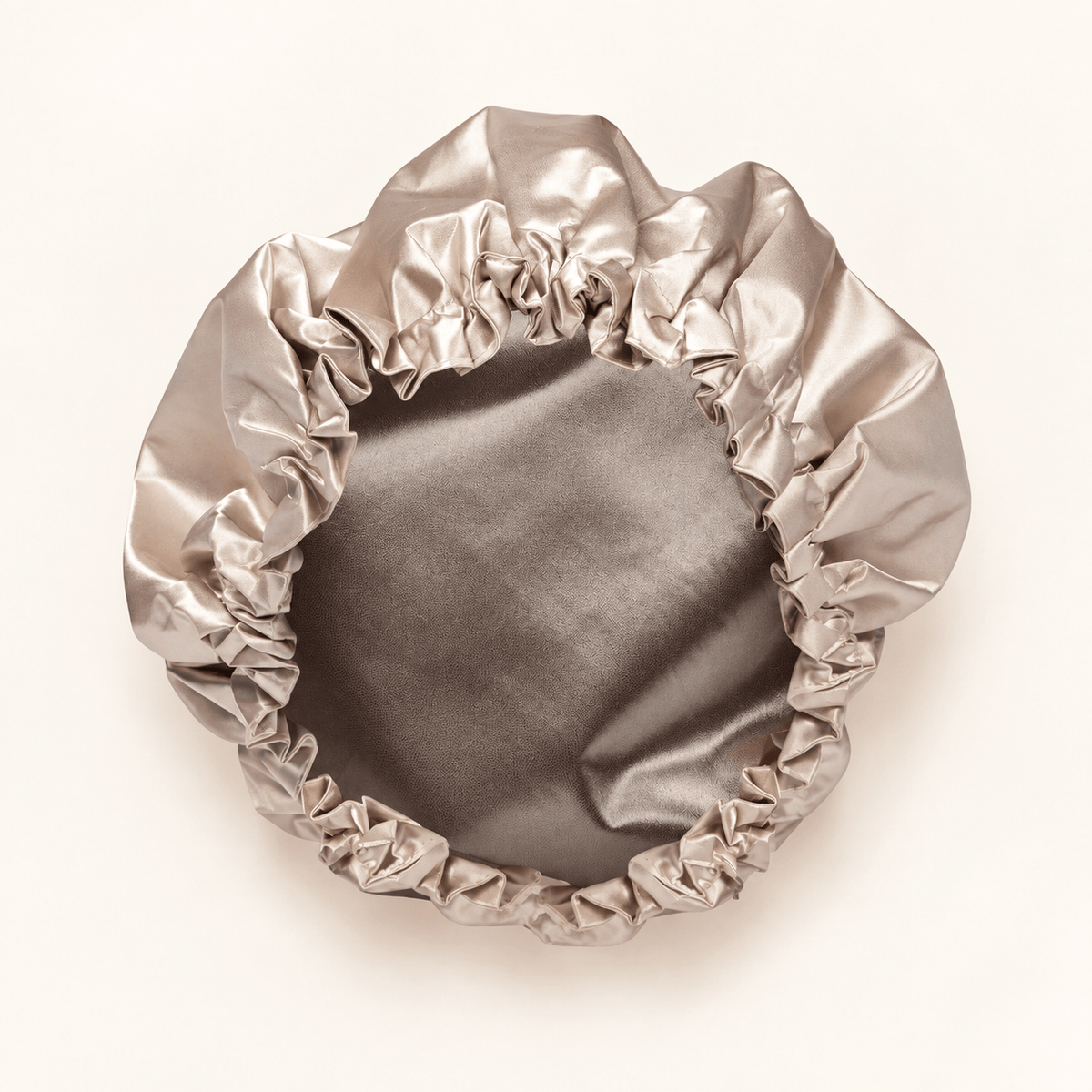 Champagne shower cap showing its satin lining and gathered elastic edge
