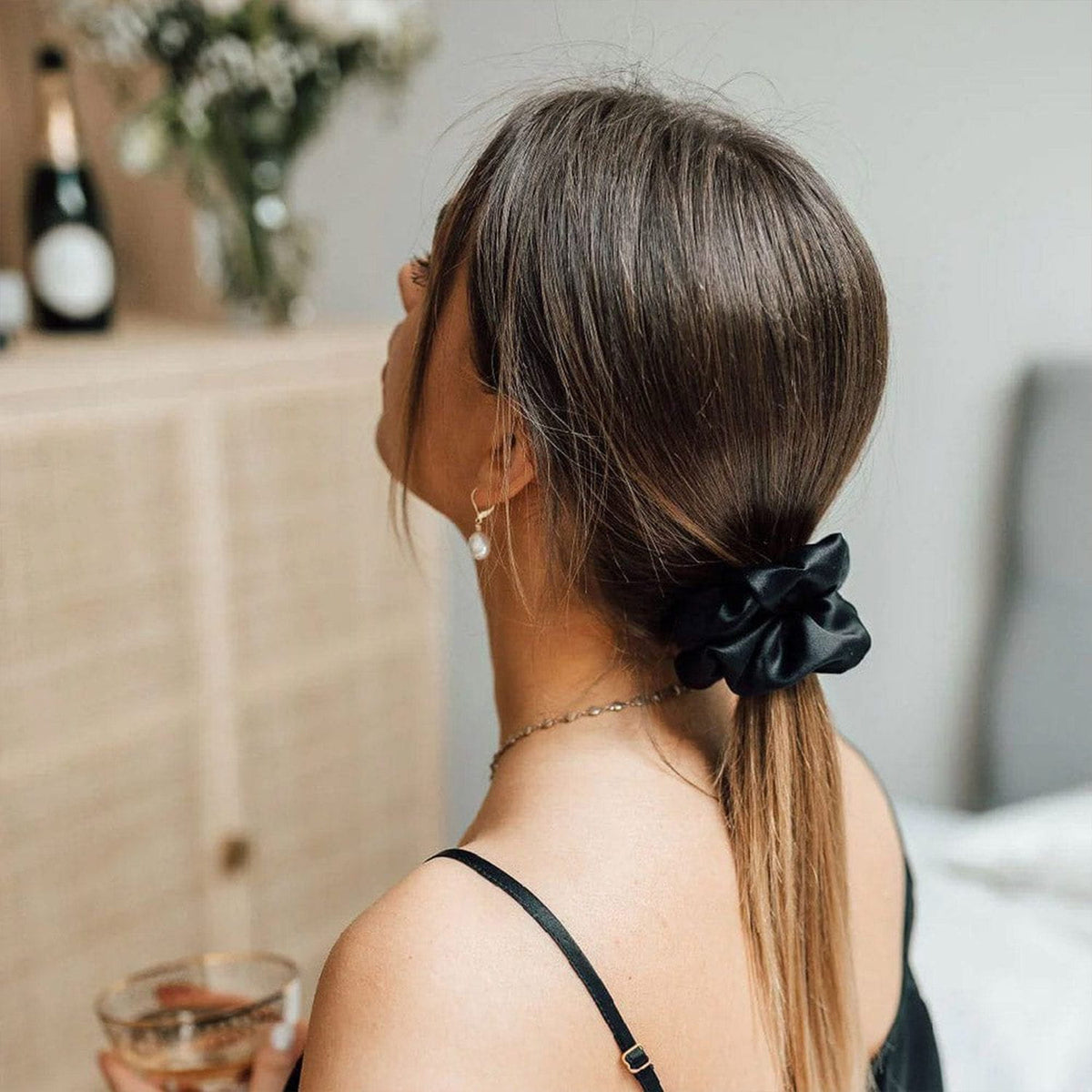 Black NIGHT Classic silk scrunchie worn in a low ponytail